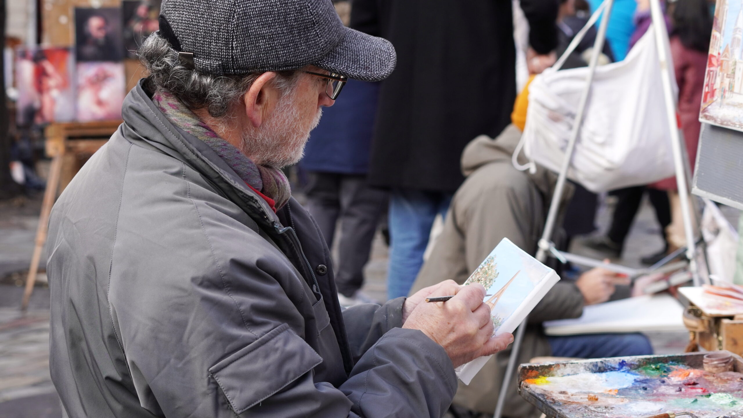 Artiste peintre réalisant un portrait sur la Place du Tertre.