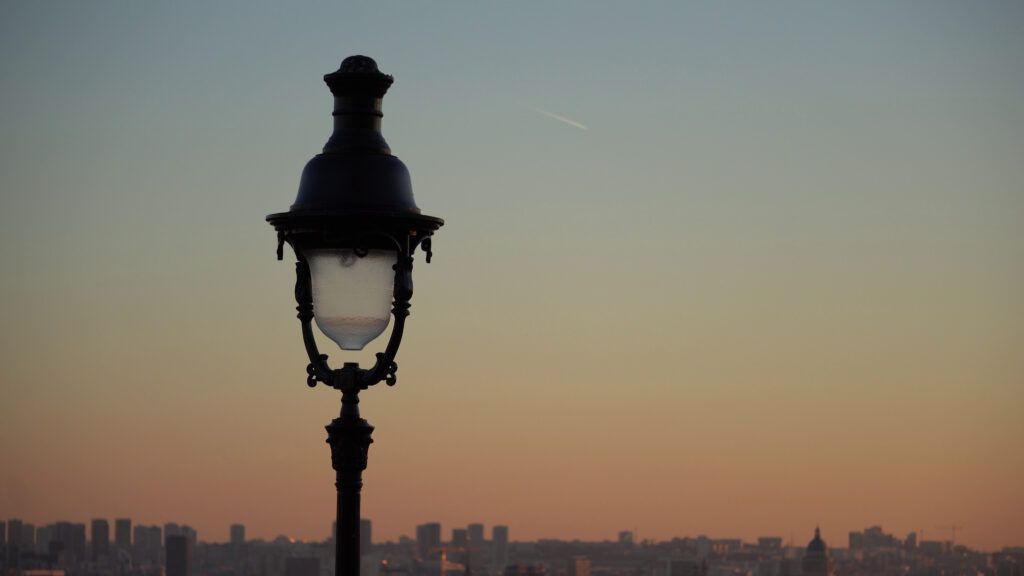 Vue sur les toits de Paris depuis Montmartre avec lampadaire au coucher du soleil.