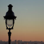 Vue sur les toits de Paris depuis Montmartre avec lampadaire au coucher du soleil.
